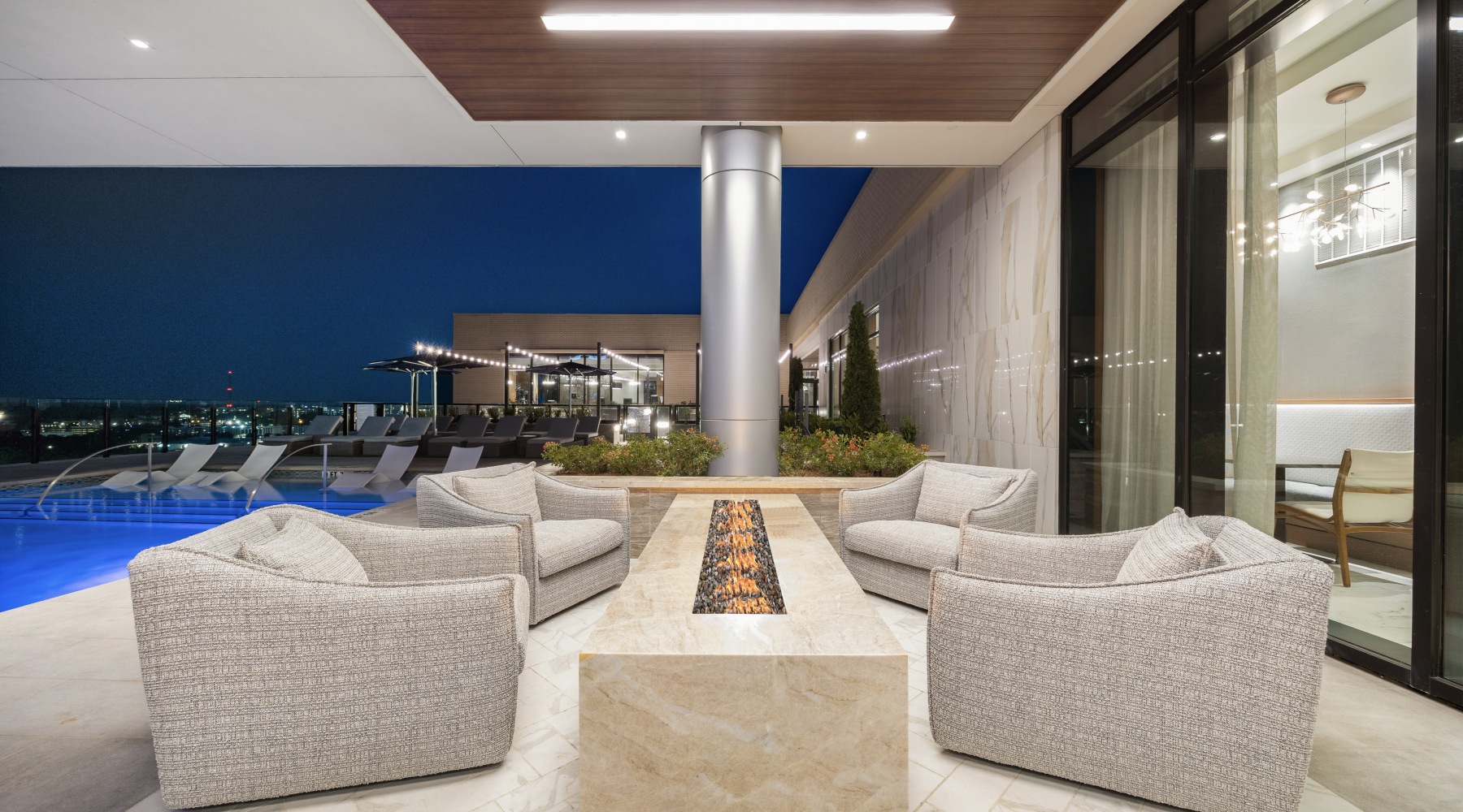outdoor fire pit with 4 armchairs on a rooftop pool deck with
