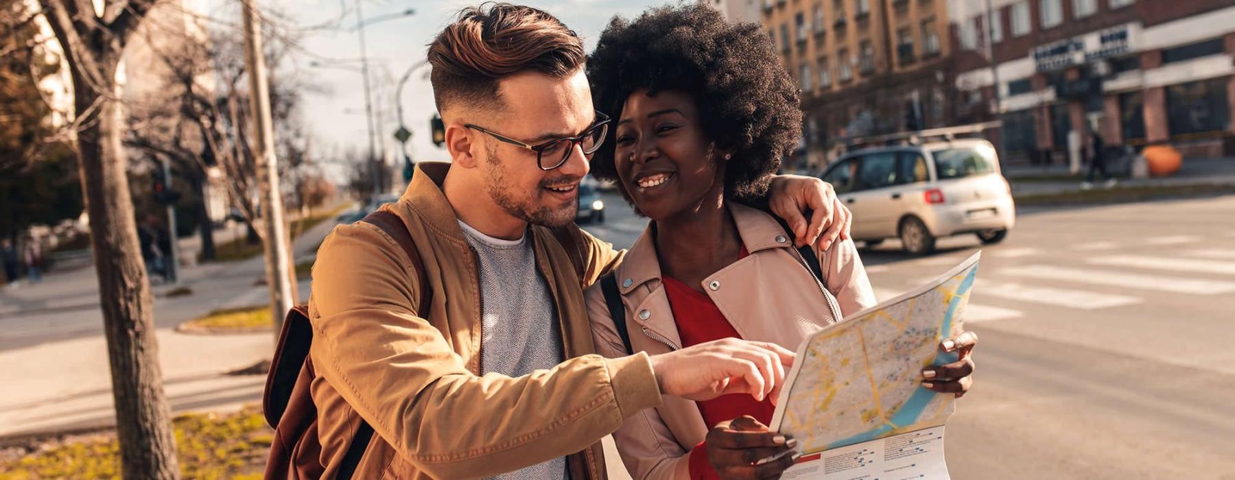 a man and woman looking at a map in the city