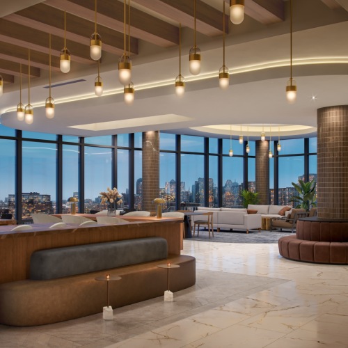 Rendering of high-rise amenity space with banquette seating, bar and entertaining area, and sofas with views of downtown Dallas in the background